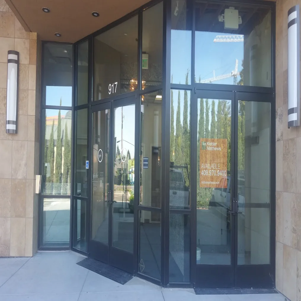 A two story aluminum storefront entrance with glass doors, sidelights and tall transom panes