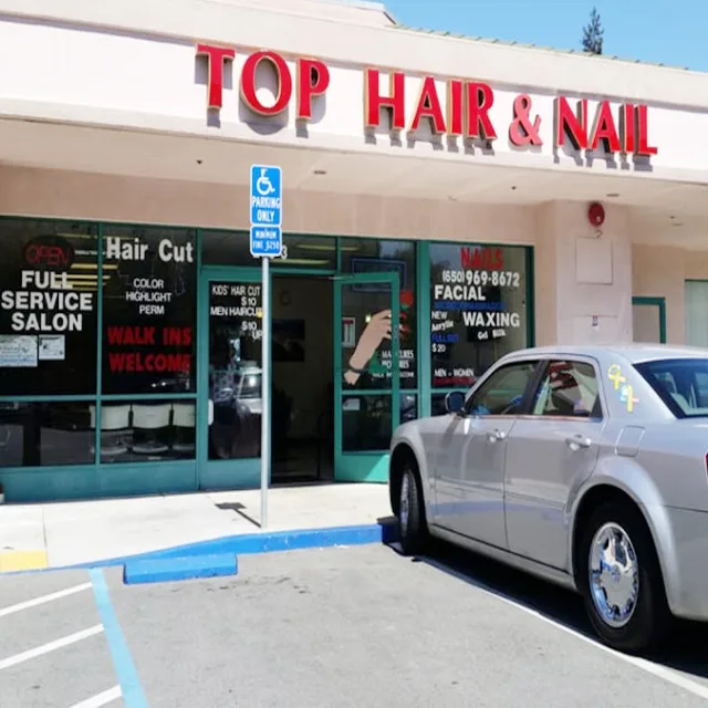 A shopping center hair and nail salon with window signs across its storefront glass