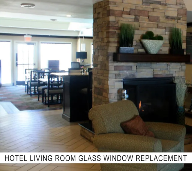 A hotel lounge with a stone fireplace, an armchair and a dining area, labeled hotel living room glass window replacement