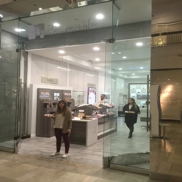 A shop inside a shopping mall with a frameless glass front and an open entrance