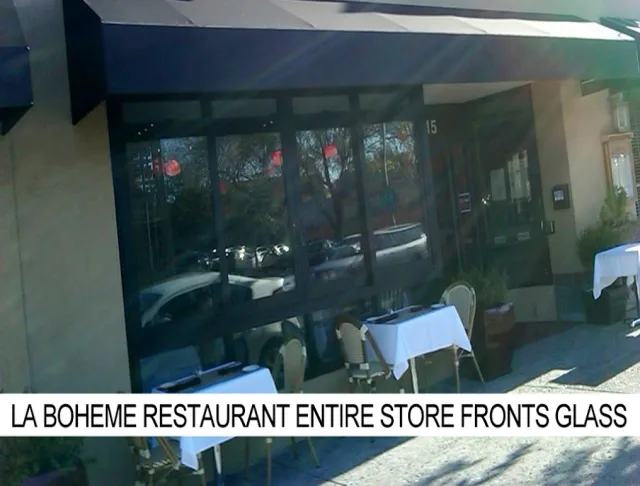 A restaurant with an awning and outdoor tables, labeled entire store front glass