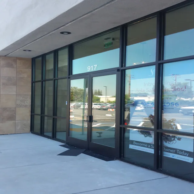 A retail suite with dark aluminum storefront windows, a double glass door and window graphics