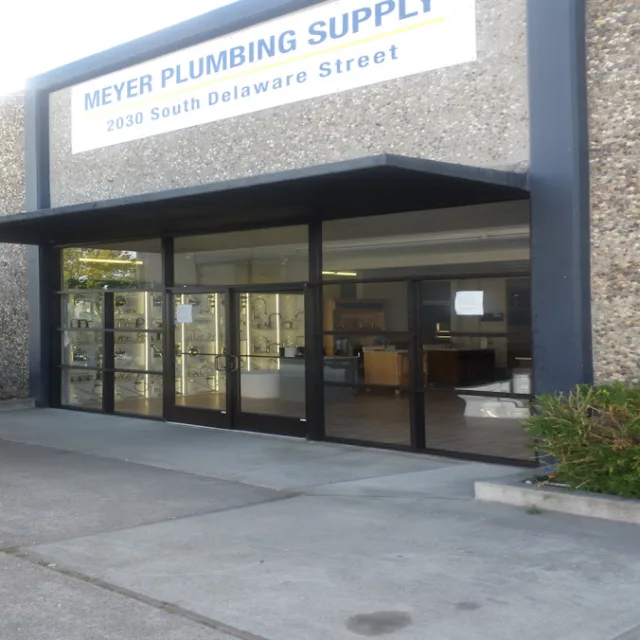 A plumbing supply store with a wide run of glass doors and windows under a flat awning